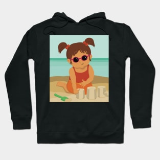 Cute little summer girl is on vacation building a sand castle on the beach Hoodie